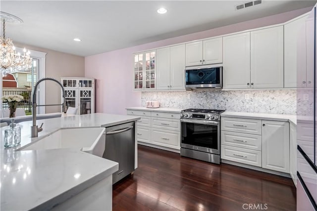 kitchen featuring stainless steel appliances, light countertops, visible vents, and a sink