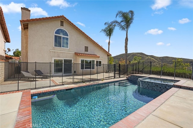 view of swimming pool with a fenced in pool, a patio area, a mountain view, an in ground hot tub, and a fenced backyard