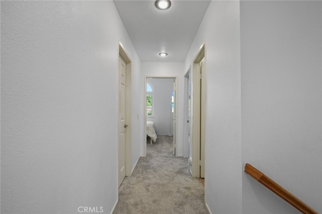 corridor with light carpet and baseboards