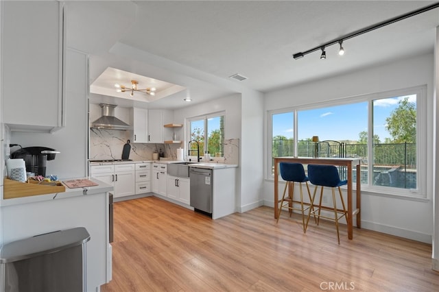 kitchen with open shelves, decorative backsplash, light wood-type flooring, dishwasher, and wall chimney exhaust hood