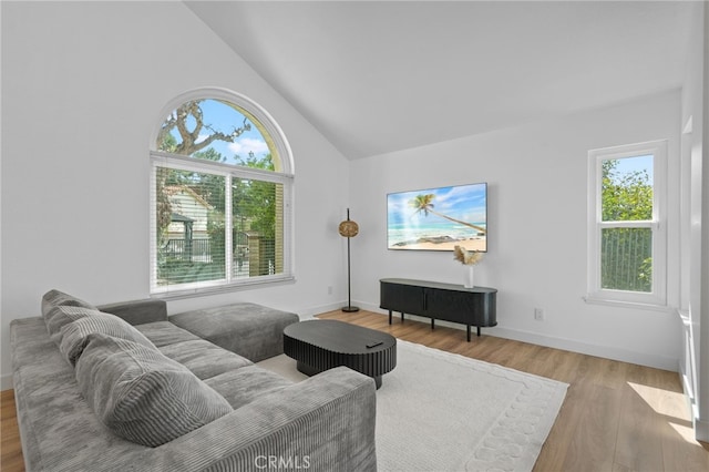 living room with high vaulted ceiling, wood finished floors, and baseboards