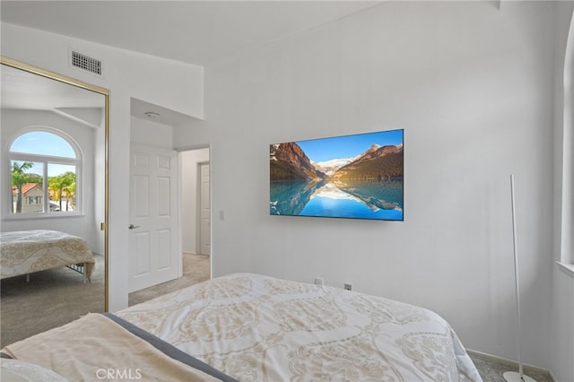 carpeted bedroom with visible vents and a closet