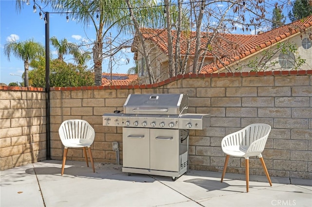 view of patio with a grill and fence