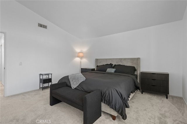 bedroom featuring vaulted ceiling, visible vents, and light colored carpet