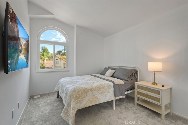 carpeted bedroom featuring vaulted ceiling and baseboards