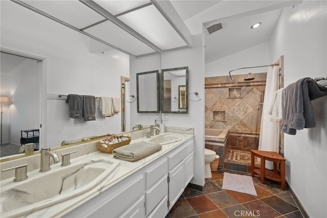 bathroom with a shower, double vanity, a sink, and toilet