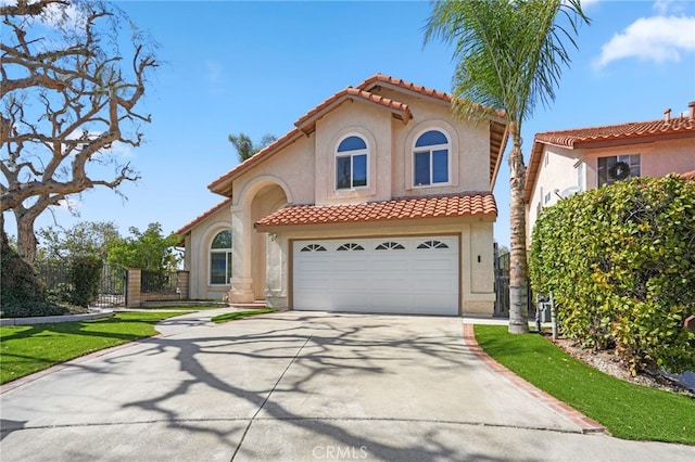 mediterranean / spanish-style house featuring a garage, driveway, a tile roof, and stucco siding