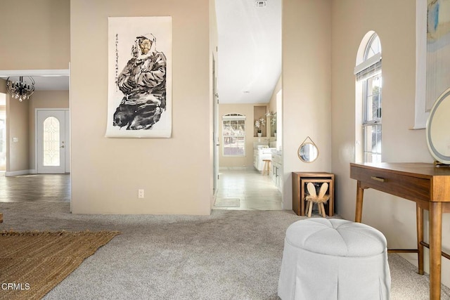 sitting room featuring carpet floors and an inviting chandelier