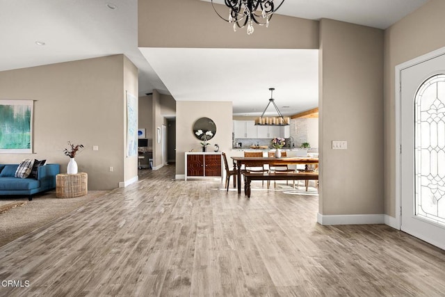 entrance foyer with light wood-type flooring, baseboards, and a chandelier