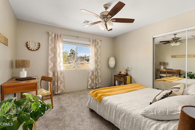 bedroom featuring a closet, visible vents, ceiling fan, and carpet