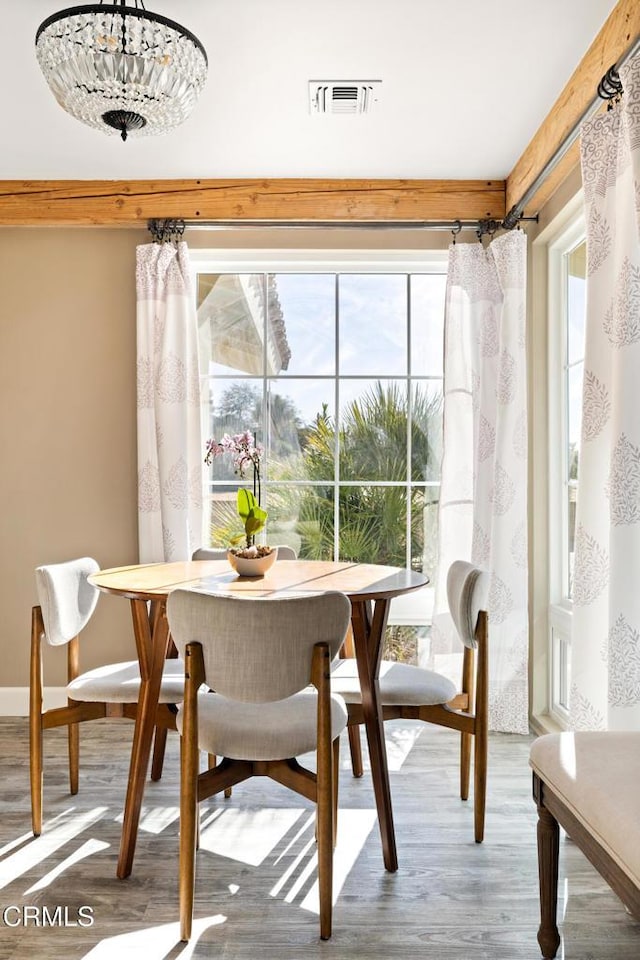 dining area with wood finished floors, visible vents, and baseboards