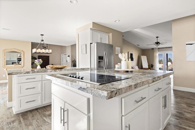 kitchen featuring light wood-style floors, black electric cooktop, a kitchen island, and stainless steel fridge with ice dispenser