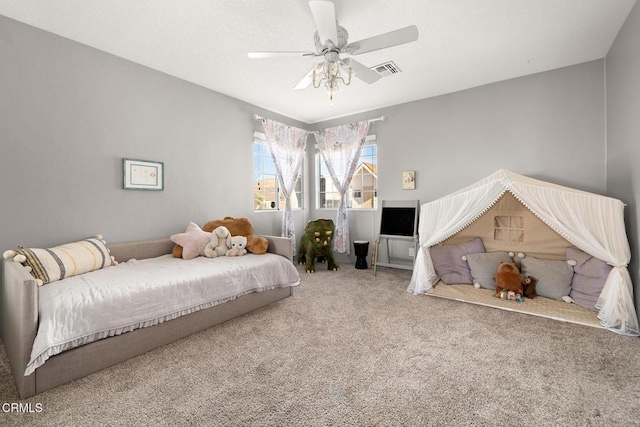 carpeted bedroom featuring a ceiling fan and visible vents