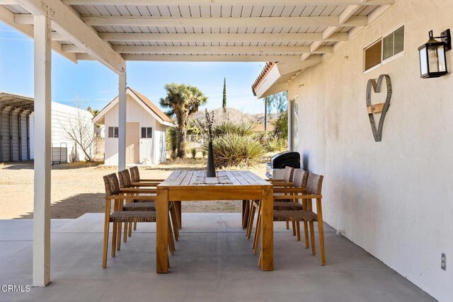 view of patio featuring an outbuilding and outdoor dining space