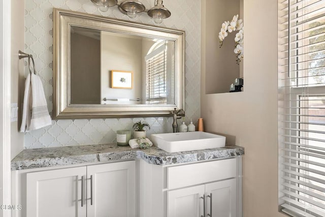 bathroom with vanity, decorative backsplash, and wallpapered walls