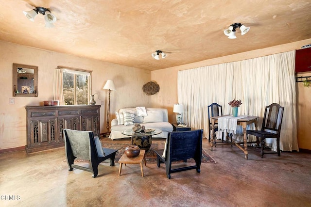 sitting room featuring finished concrete flooring and baseboards