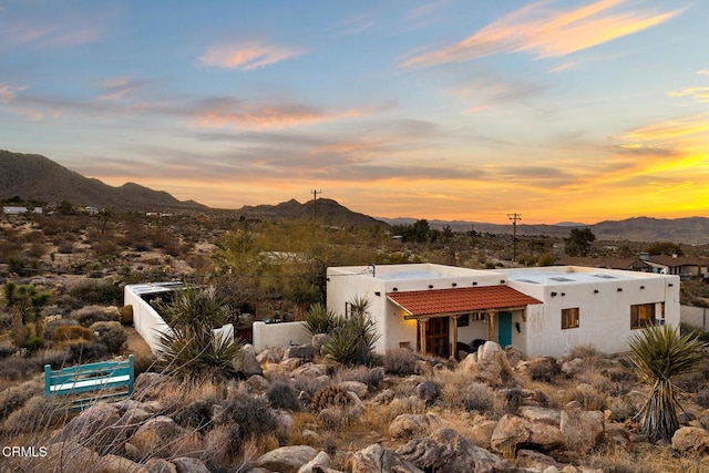 rear view of house featuring a tiled roof, a mountain view, and stucco siding