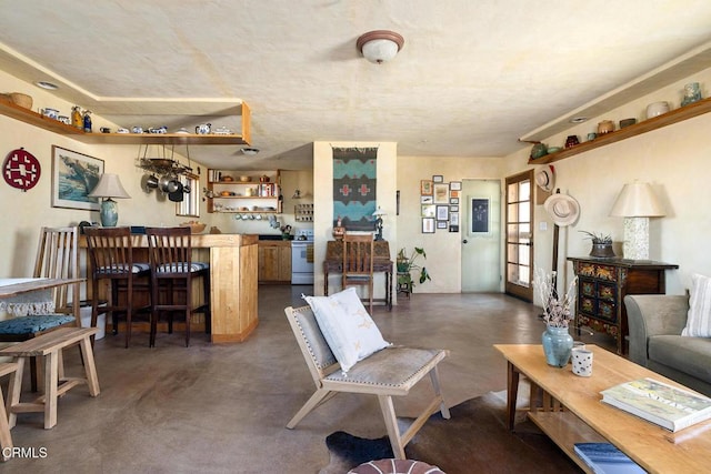 living room with finished concrete flooring and a bar