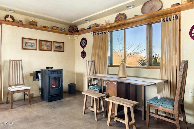 dining area with concrete flooring and a wood stove