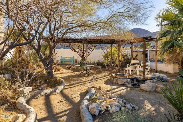 view of yard featuring a patio, fence, and a mountain view