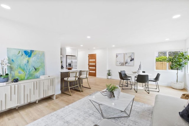 living room featuring light wood finished floors, baseboards, and recessed lighting