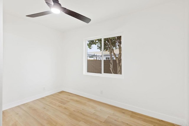 unfurnished room with wood finished floors, baseboards, and ceiling fan