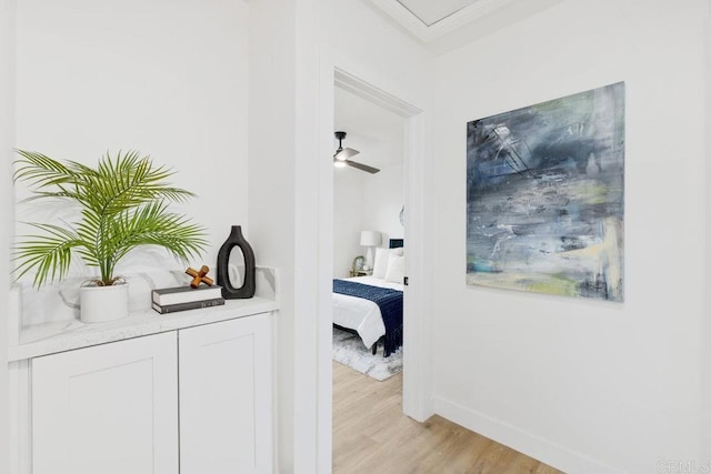 hall featuring baseboards and light wood-type flooring