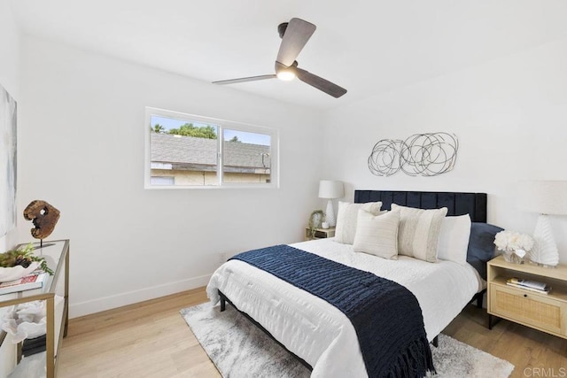 bedroom with ceiling fan, baseboards, and wood finished floors