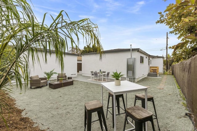rear view of house with a patio area, a fenced backyard, entry steps, an outdoor hangout area, and stucco siding