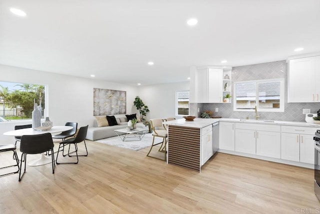 kitchen featuring stainless steel dishwasher, a sink, recessed lighting, and white cabinetry