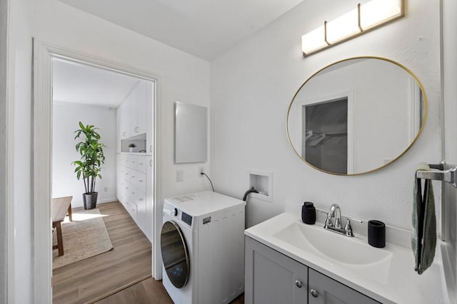 bathroom with washer / clothes dryer, wood finished floors, and vanity