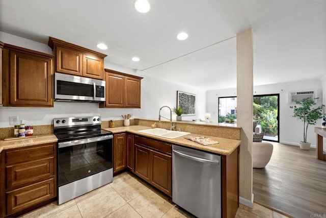 kitchen with stainless steel appliances, recessed lighting, a sink, a peninsula, and baseboards