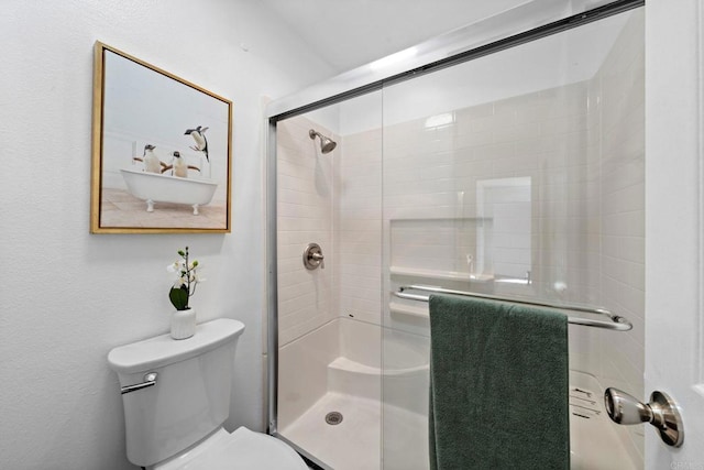 bathroom with a stall shower and toilet