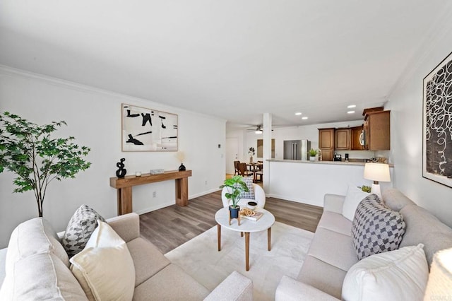 living area with ceiling fan, light wood finished floors, recessed lighting, and crown molding