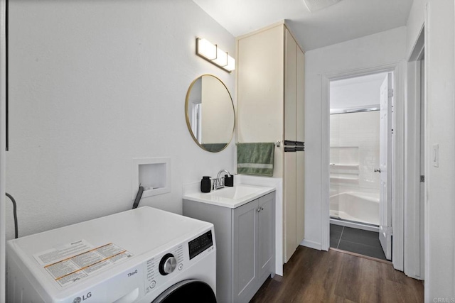 clothes washing area with washer / dryer, laundry area, dark wood-style flooring, and a sink