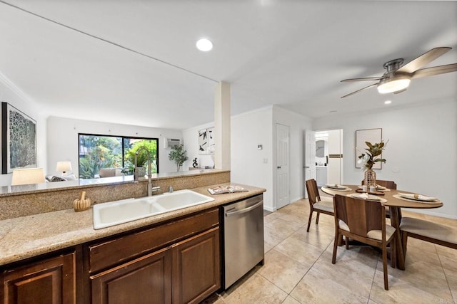 kitchen featuring light countertops, dark brown cabinets, stainless steel dishwasher, a sink, and light tile patterned flooring