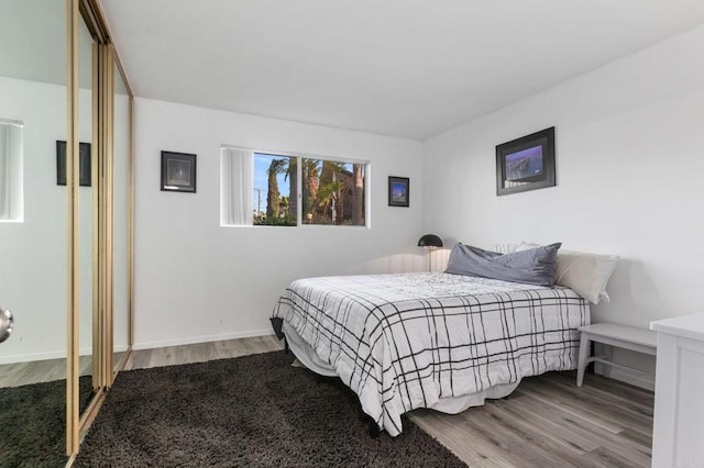 bedroom featuring baseboards and wood finished floors