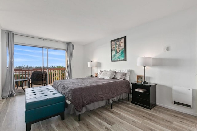 bedroom featuring access to outside, light wood-style flooring, and baseboards