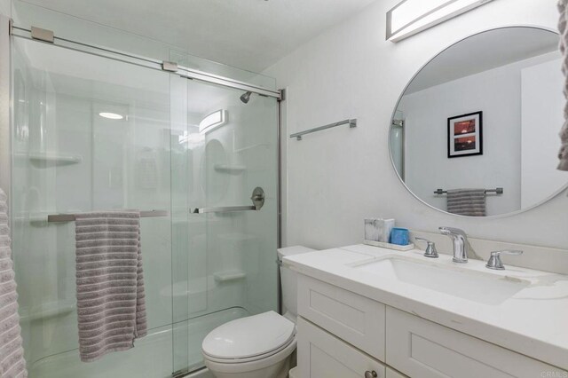 bathroom featuring an enclosed shower, toilet, and vanity