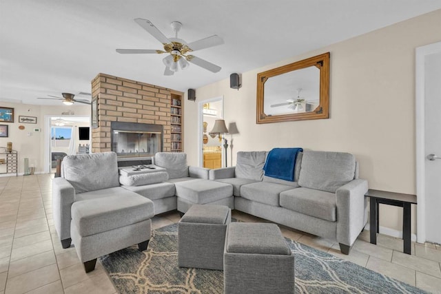 living area featuring a brick fireplace, ceiling fan, baseboards, and tile patterned floors