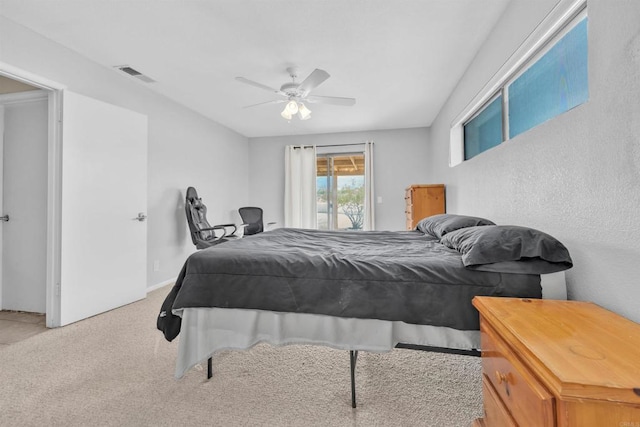 carpeted bedroom with visible vents and a ceiling fan