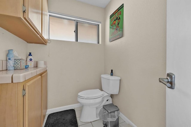 bathroom featuring tile patterned flooring, toilet, and baseboards