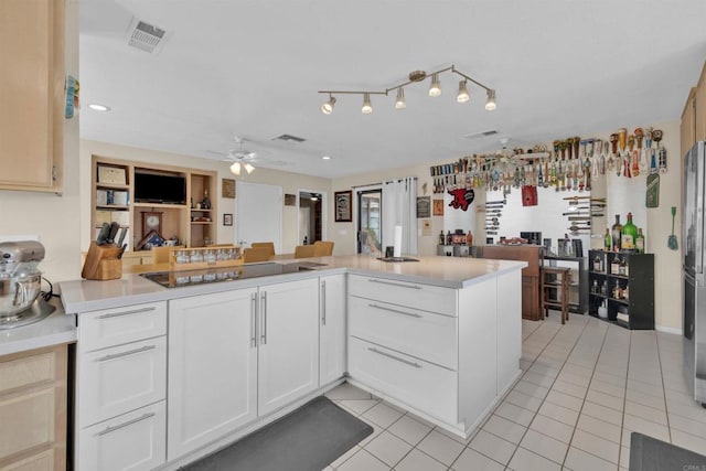 kitchen with a ceiling fan, black electric cooktop, light countertops, and light tile patterned floors