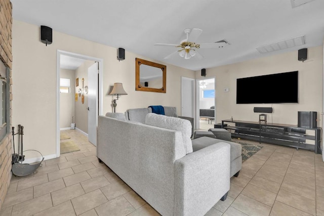 living area with light tile patterned floors, baseboards, visible vents, and a ceiling fan