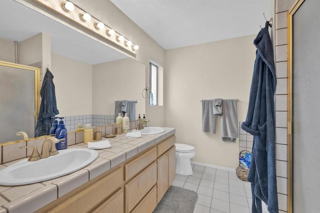 full bathroom with toilet, a stall shower, tile patterned flooring, and a sink