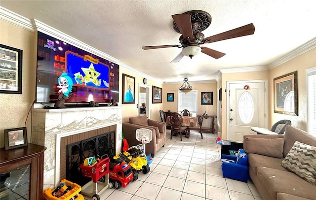 living room with a fireplace, light tile patterned floors, ornamental molding, ceiling fan, and a textured ceiling