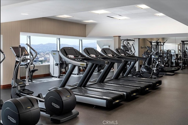 exercise room with baseboards and a mountain view