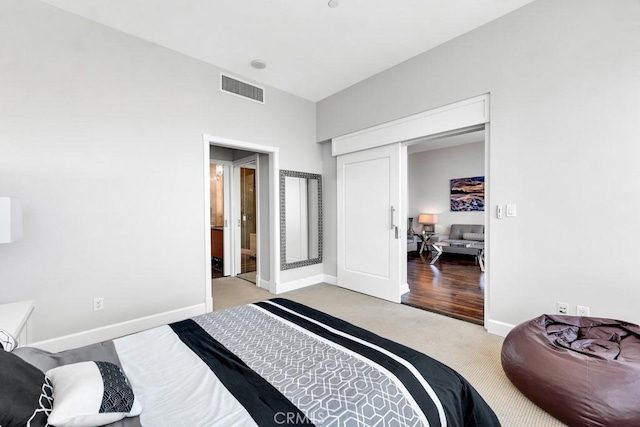 carpeted bedroom featuring baseboards and visible vents