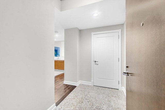 hallway with baseboards and wood finished floors