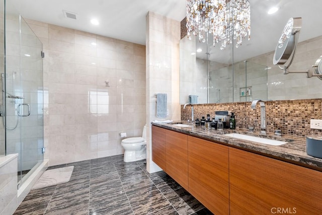 bathroom featuring visible vents, double vanity, a sink, and tile walls